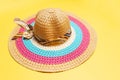 Close-up of women summer hat with ribbon bow and lines of white, pink and blue colors on yellow background. Royalty Free Stock Photo