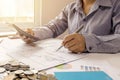 Close-up of women using calculators and note-taking, accounting reports.