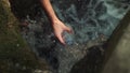 Close-up of women's hands filling clean water in a plastic bottle from a mountain river.