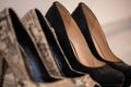 A close up of a women's shoe, snake leather peep toe and black suede pumps Royalty Free Stock Photo