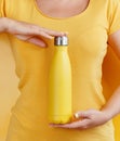 Close up of women holding yellow reusable steel bottle