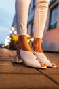 Close-up of a womens fashionable summer shoes on street at night