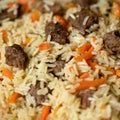 Close up of wonderful Uzbek pilaf. Food background or texture with rice and meat dish. Soft focus