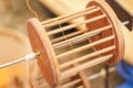 Close up wood equipment reeling the thread from gold silkworm cocoons in pot on charcoal stove for make silk thread,silk fabric Royalty Free Stock Photo