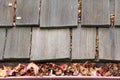 Close up on wood shingle roof with rain gutter clogged with leaves Royalty Free Stock Photo