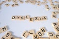 close-up wooden alphabet blocks, DYSLEXIA word on white background, dyslexia awareness, help with reading, learning difficulties,