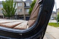 Close-up of wooden bench armrest - suburban street background Royalty Free Stock Photo