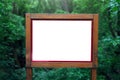 Close-up of wooden billboard with empty blank in forest. Mockup concept