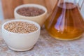 Wheat grains in wooden bowl and oil in decanter