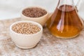 Wheat grains in wooden bowl and oil in decanter