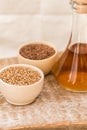 Wheat grains in wooden bowl and oil in decanter