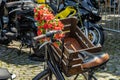 Close-up of a wooden box in front of a bicycle adorned with red plastic flowers Royalty Free Stock Photo