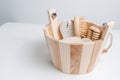 Close-up of wooden bucket with set of bath accessories against white-grey background. Royalty Free Stock Photo