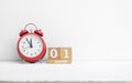 Close up of wooden calendar date 01 January with red alarm clock