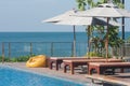 Close up wooden daybed locate beside the swimming pool.