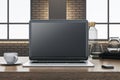 Close up of wooden designer office desk with empty computer, supplies and coffee cup. Blurry brick wall and window with city view Royalty Free Stock Photo