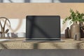 Close up of wooden designer workplace with reflections on laptop screen, coffee cup, supplies and other items.