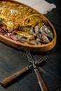 Close-up wooden dish with grilled fish. Sea food with vegetables on a dark wooden table. Sea trout. Delicious and healthy lunch or Royalty Free Stock Photo