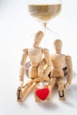 Close up of wooden figure stand for love forever with hourglass Royalty Free Stock Photo