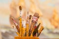 Close up of wooden flask with paint brushes in a blurred background