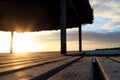 Close up of wooden gazebo on the beach at sunset or sunrise. Background of a seashore with palm trees and blue water in the early