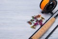 Close-up of a wooden handle from a fishing rod, a reel with a fishing line and a bait with a hook, for catching fish, on a light Royalty Free Stock Photo