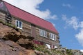 Close up of wooden huts on rock. Small one-story houses on mountain in sunny weather.