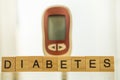 Close up of wooden letters block wording and Glucose meter as background using as Medicine, diabetes, glycemia, health care and