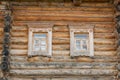 Close up of wooden log house. two windows on the wall Royalty Free Stock Photo