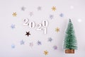 Close-up of wooden numbers 2021 on grey background with stars and cristmas tree . Change year 2020 to 2021. content