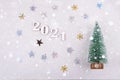 Close-up of wooden numbers 2021 on grey background with stars and cristmas tree . Change year 2020 to 2021