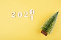 Close-up of wooden numbers 2021 on orange background with stars and cristmas tree . Change year 2020 to 2021