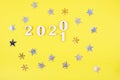 Close-up of wooden numbers 2021 on yellow background with stars . Change year 2020 to 2021. Holidays content