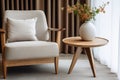 Close up of wooden round coffee table near beige fabric mid-century armchair. Scandinavian style home interior design