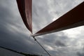 Close up of the wooden spar boom on a small sailing dinghy with a red sail