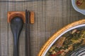 Close-up of wooden spoon and chopsticks next to a rattan rice bowl, inside is a traditional Vietnamese lunch, rice, soup, salty Royalty Free Stock Photo