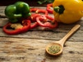 Close up wooden spoon with utensils herbs , colorful bell pepper at background