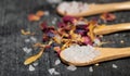 Close-up of wooden spoons containing grains of salt. Other spoons and dried flowers in the background