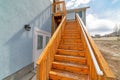 Close up of wooden stairway with handrails at home exterior against cloudy sky Royalty Free Stock Photo