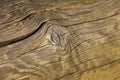 a close up of a wooden surface with a clock on it's face and a small hole in the wood,