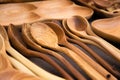 Close up of wooden utensils for the kitchen, bowls, spoons on dark background. Concept of natural dishes, a healthy lifestyle.