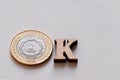 Close-up of the word OK made from 2 peso coins and wooden letters on a white background. Argentina currency. The concept of