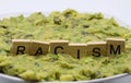 Close up of  word racism spelled by wooden letters on disgusting green slimy stodge focus on word center Royalty Free Stock Photo