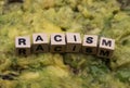 Close up of  word racism spelled by wooden letters on disgusting green slimy stodge focus on word center Royalty Free Stock Photo