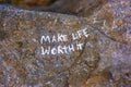 Close up of the words Make Life Worth It on rock