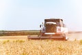 Close up The work of a combine harvester on a wheat field on a sunny day Royalty Free Stock Photo