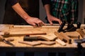 Close-up of the work of a man and a boy at a carpenter`s table, on the table are a plane, chisel, Board, workbench