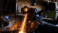 Close-up of worker cutting metal with grinder. Frame. Sparks while grinding iron. Circular cutting disc cuts of metal Royalty Free Stock Photo