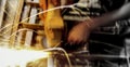 Close-up of worker cutting metal with grinder. Sparks while grinding iron. Industry, soft selective focus Royalty Free Stock Photo