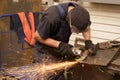 Close-up of worker cutting metal with grinder. Sparks while grinding iron.